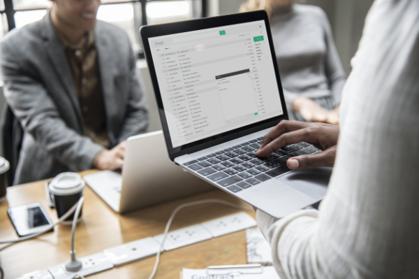 Business professionals collaborating on digital solutions with laptop displaying analytics dashboard